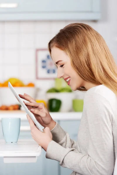 Jovem mulher usando um tablet em casa — Fotografia de Stock