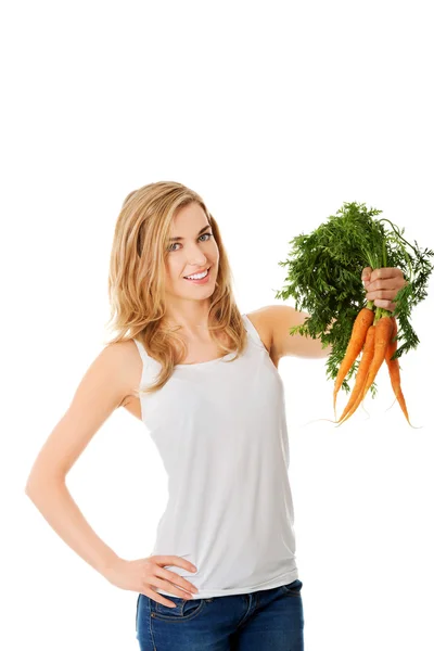Молодая женщина с морковкой — стоковое фото