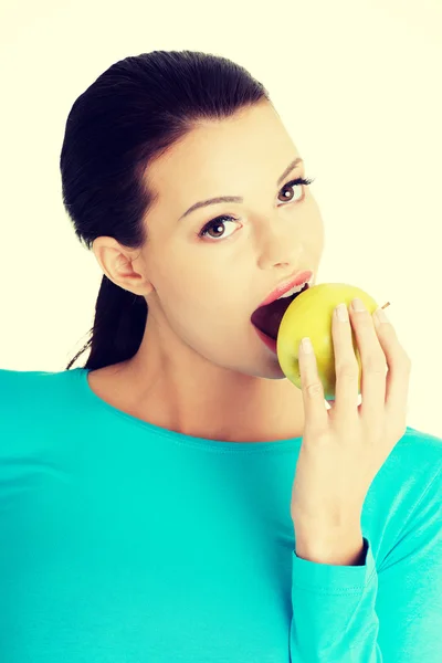 Aantrekkelijke jonge vrouw eten van groene appel. — Stockfoto