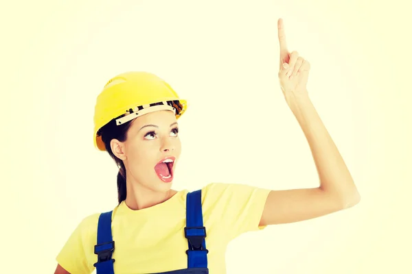 Mujer trabajadora de la construcción apuntando al espacio de copia — Foto de Stock