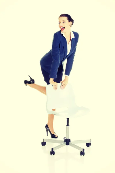 Kobieta stojąc obok krzesło ofice — Zdjęcie stockowe