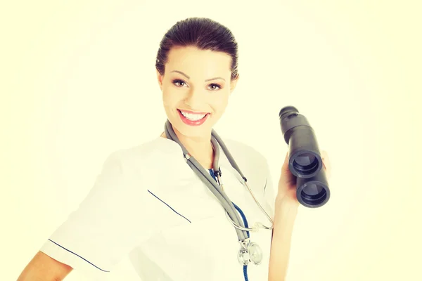 Female doctor looking through binoculars. — Stock Photo, Image