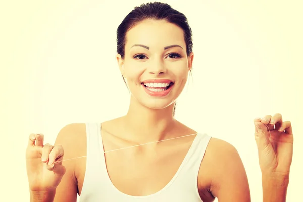 Beautiful young woman using dental floss — Stock Photo, Image