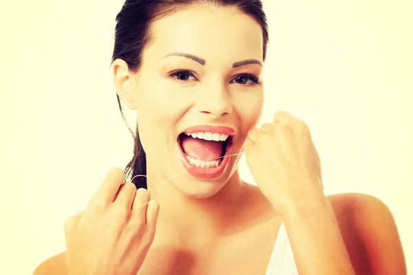 Beautiful young woman using dental floss — Stock Photo, Image