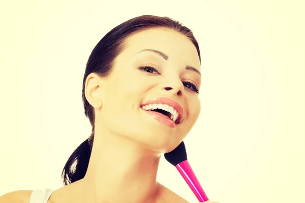 Mujer atractiva haciendo maquillaje en la cara . — Foto de Stock