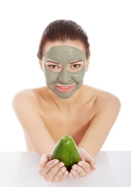 Beautiful spa woman in facial mask and avocado clipart