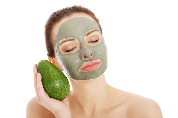 Güzel kadın yüz maskesi ve avokado — Stok fotoğraf