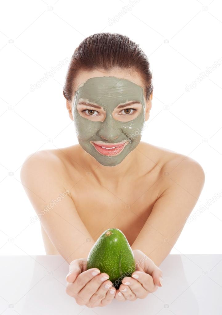 Beautiful spa woman in facial mask and avocado