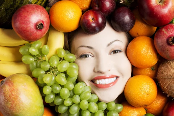 Jonge vrouw in groep van fruit. — Stockfoto