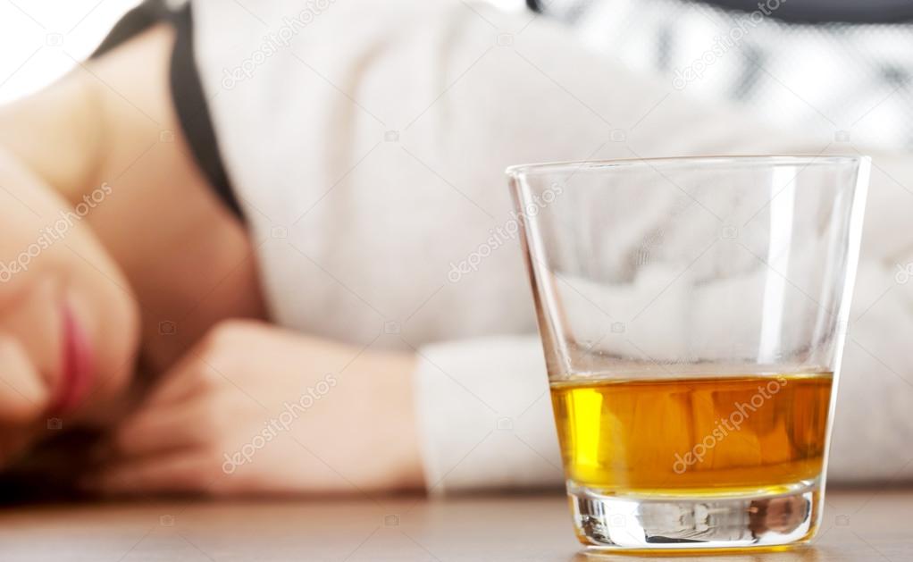 Yound woman in depression, drinking alcohol