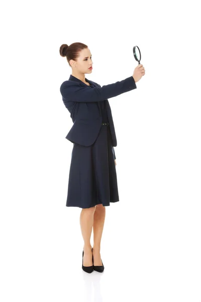 Affärskvinna som undersöker ett förstoringsglas — Stockfoto