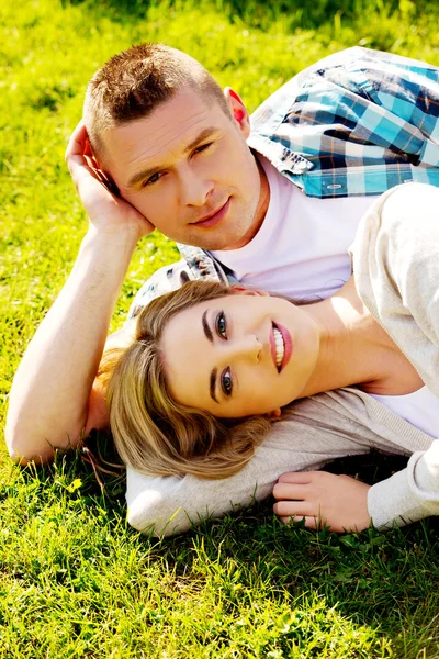 Par liggande på gräset — Stockfoto