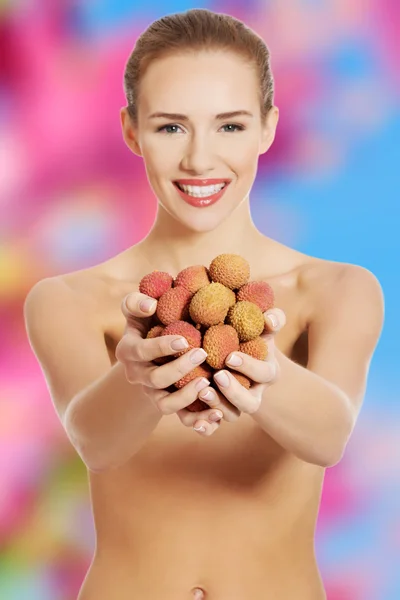 Naakte vrouw bedrijf litchi — Stockfoto