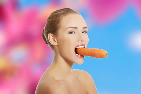 Woman with a carrot in mouth — Stock Photo, Image