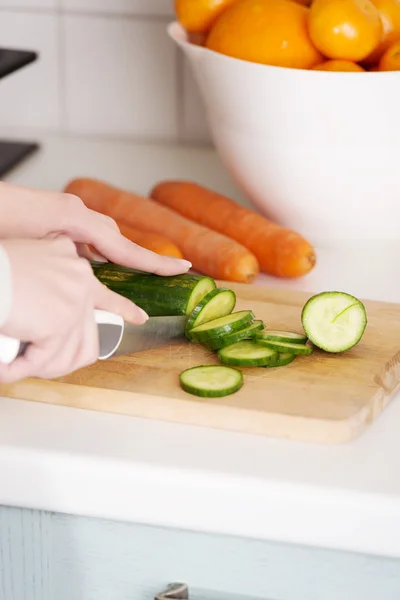 Woman slicing cucumber — Stock Photo, Image