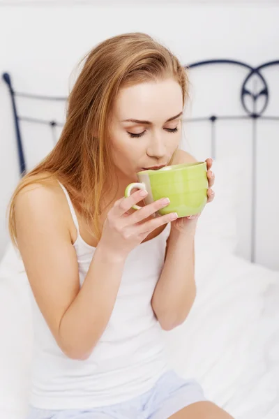 Mujer bebiendo té en la cama — Foto de Stock