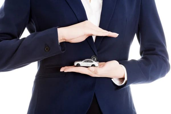 Businesswoman holding a model of car — Stock Photo, Image