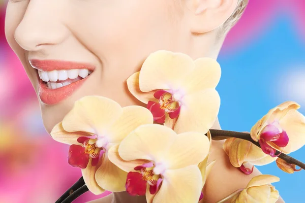 Bella donna con un fiore di orchidea — Foto Stock