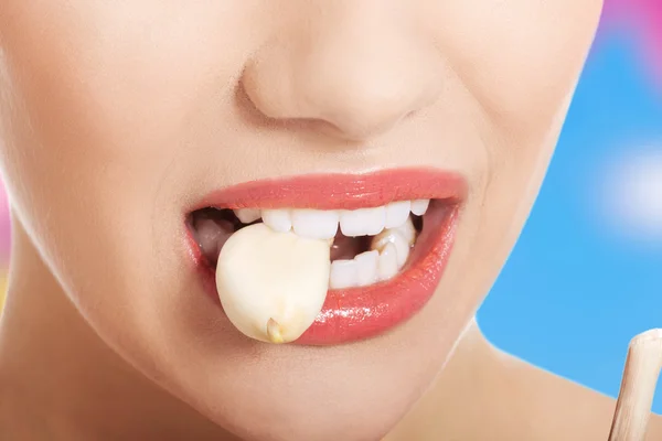 Young woman eating garlic — Stock Photo, Image