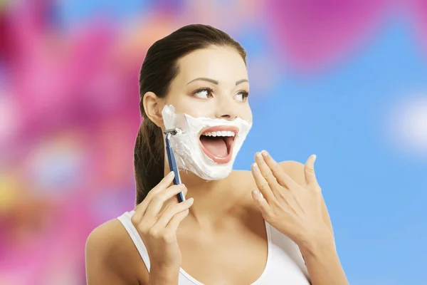 Женщина бреется лицом — стоковое фото