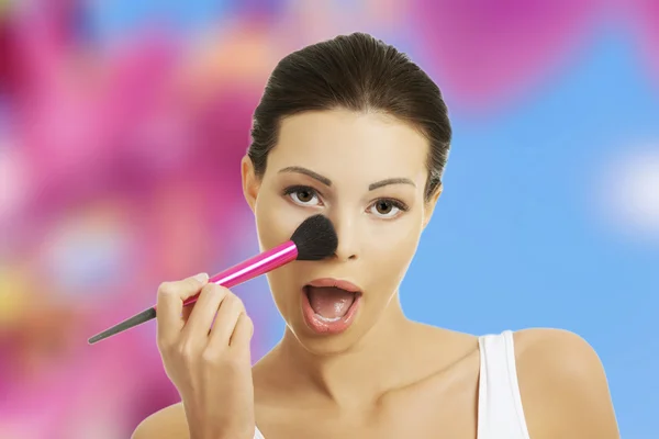 Mujer joven aplicando maquillaje —  Fotos de Stock