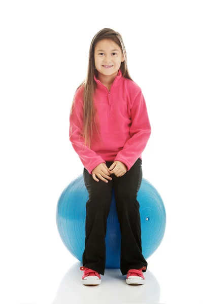 Girl sitting on a big ball — Stock Photo, Image