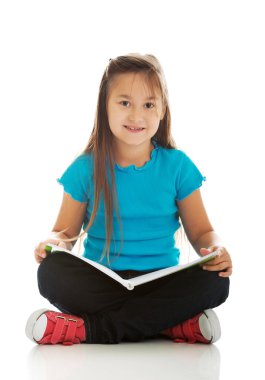 Çapraz bacaklı oturan ve öğrenme küçük kız