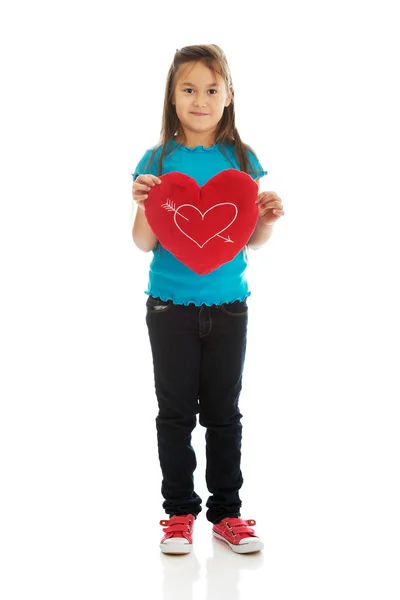 Menina segurando travesseiro coração — Fotografia de Stock