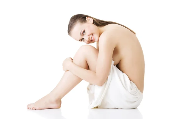 Sitting nude woman wearing towel — Stock Photo, Image