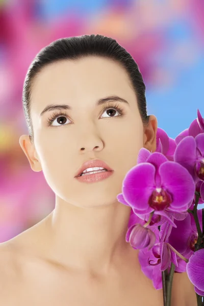 Hermosa mujer con una flor de orquídea —  Fotos de Stock