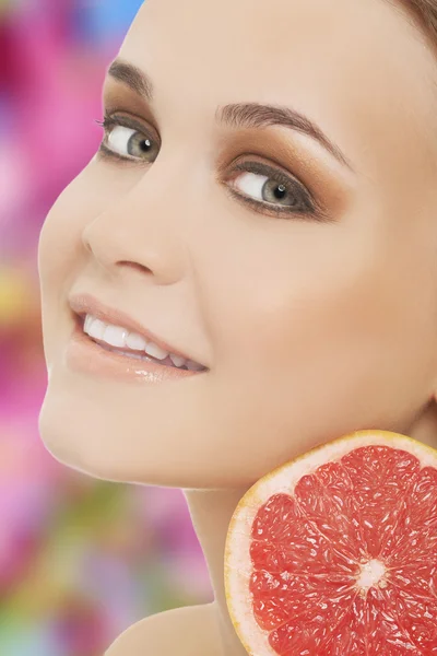 Jonge brunette met rode grapefruit — Stockfoto