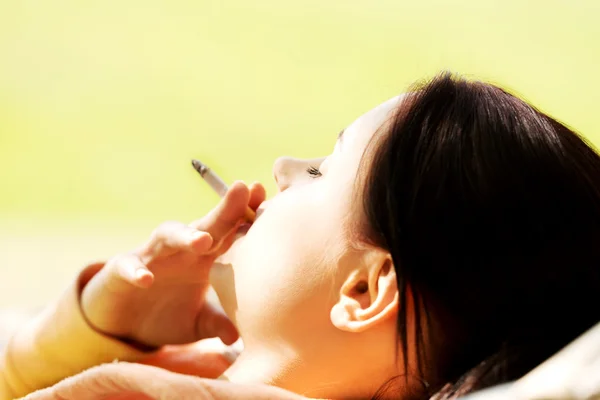 Vrouw roken op een hangmat — Stockfoto