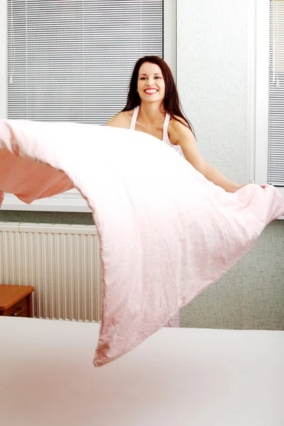 Žena dělat postel — Stock fotografie