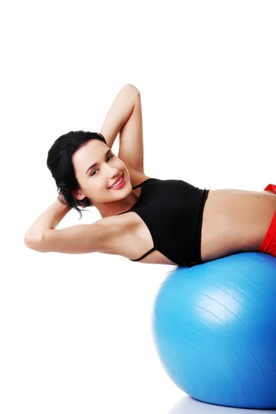 Jeune femme excerçant sur boule — Photo