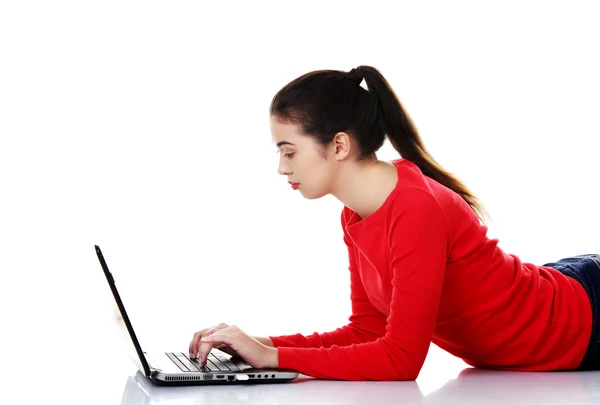 Junge Frau liegt mit Laptop — Stockfoto