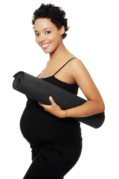 Pregnant woman with a small carpet — Stock Photo, Image