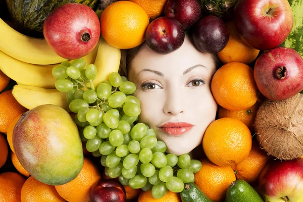 Woman in group of fruits — Stock Photo, Image