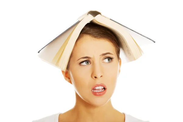 Woman holding book on head — Stock Photo, Image