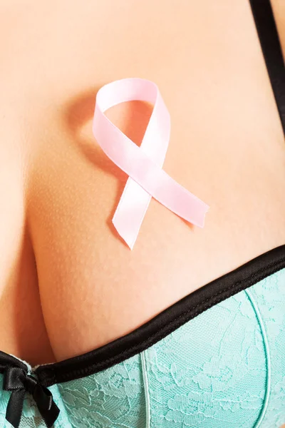 Pink ribbon on woman's breast — Stock Photo, Image