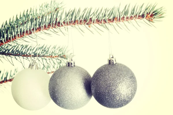 Tre julgranskulor hänger på en kvist. — Stockfoto