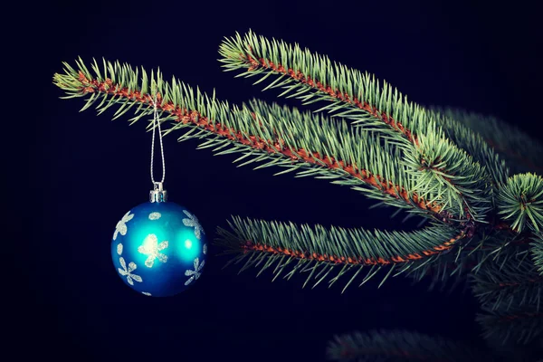 Eine Weihnachtskugel reicht einen Zweig weiter. — Stockfoto