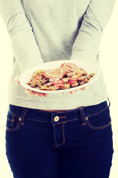 Hermosa joven con galletas en un plato . — Foto de Stock