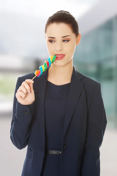 Beautiful businesswoman eating lollipop — Stock Photo, Image