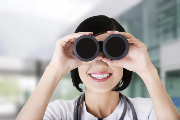 Female doctor looking through the binocular — Stock Photo, Image