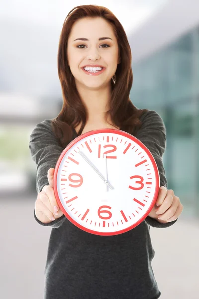 Femme tenant horloge de bureau — Photo