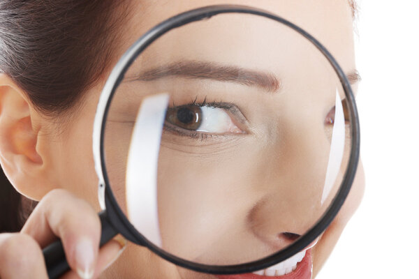 Женщина смотрит через увеличительное стекло
