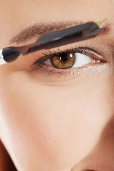 Woman brushing her eyebrow — Stockfoto