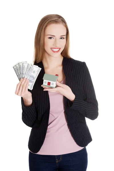 Женщина с моделью дома и долларовыми купюрами — стоковое фото