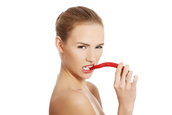 Mulher nua mordendo uma pimenta — Fotografia de Stock