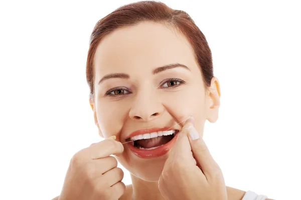 Mujer limpiando dientes con hilo dental — Foto de Stock